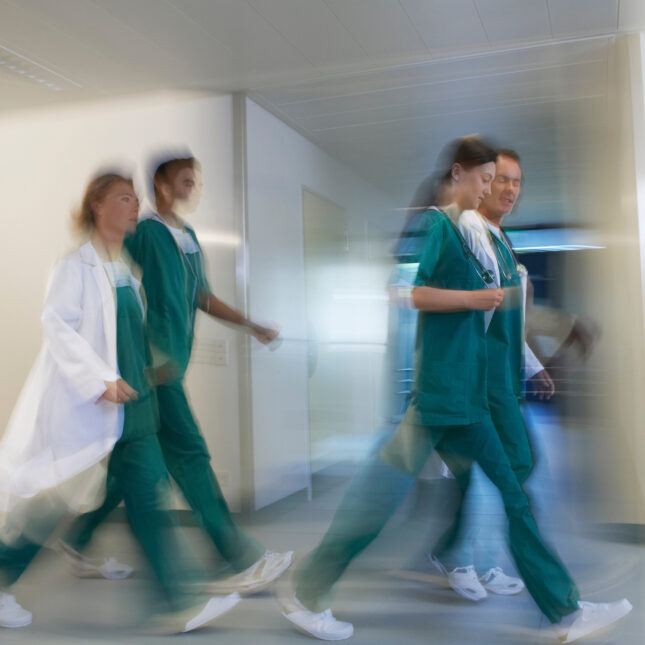 A group of four physicians rush through a hospital corridor — coverage from STAT