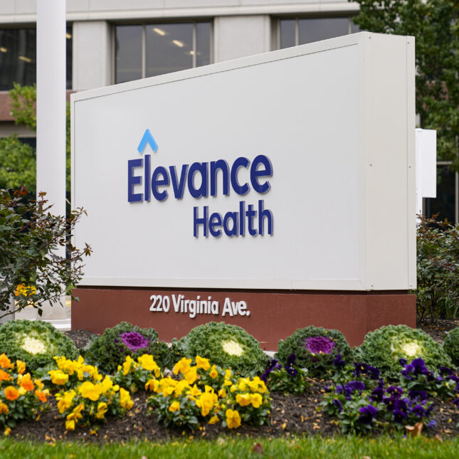 A sign of Elevance Health behind some flowers — coverage from STAT