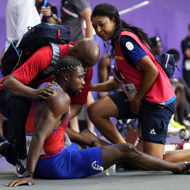 Noah Lyles, of the United States, is treated by medical staff following the men's 200-meters final at the 2024 Summer Olympics, Thursday, Aug. 8, 2024, in Saint-Denis, France. (AP Photo/Petr David Josek)