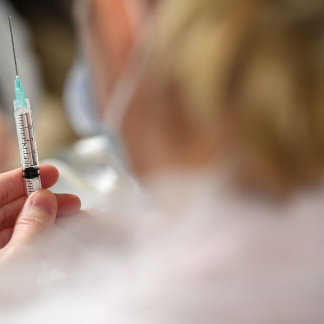 A file news photograph of a vaccine syringe being held by a nurse