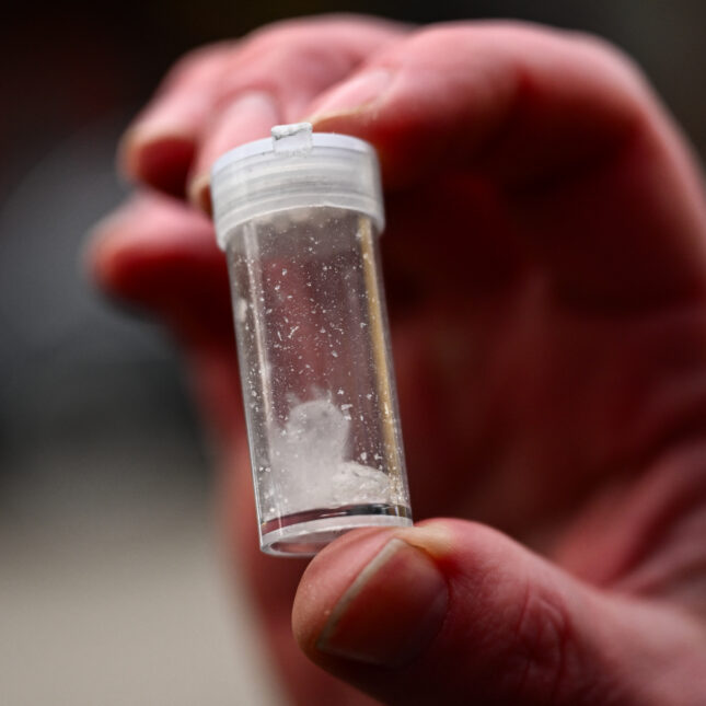 A hand holds a vial of meth — health coverage from STAT