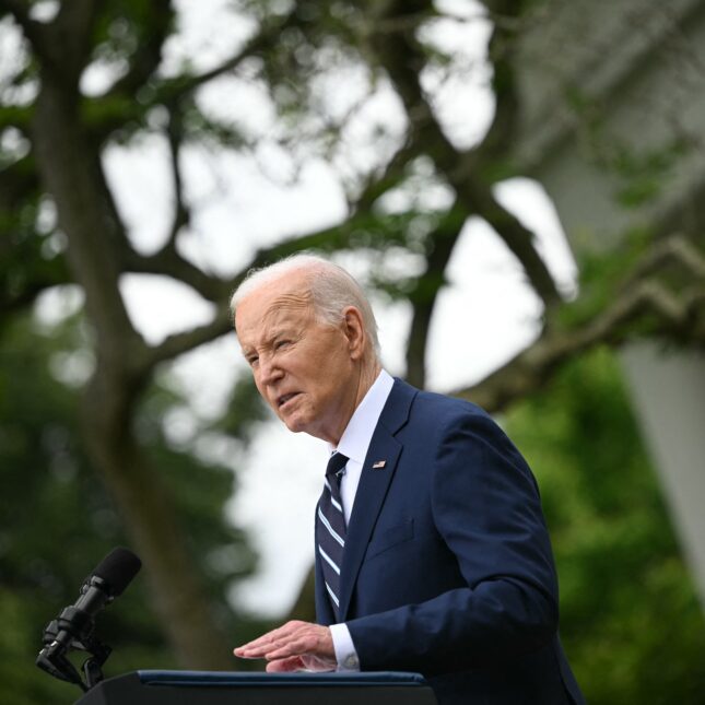 President Joe Biden speaks and gestures at a podium outdoor