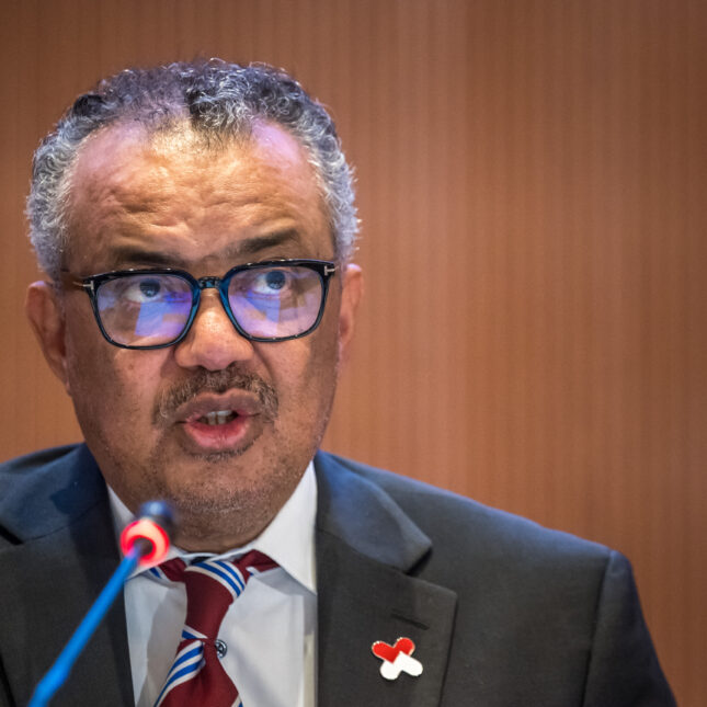 Close up news photograph of World Health Organization (WHO) Director-General Tedros Adhanom Ghebreyesus (R) delivers his speech on the opening day of the 77th World Health Assembly, in Geneva on May 27, 2024