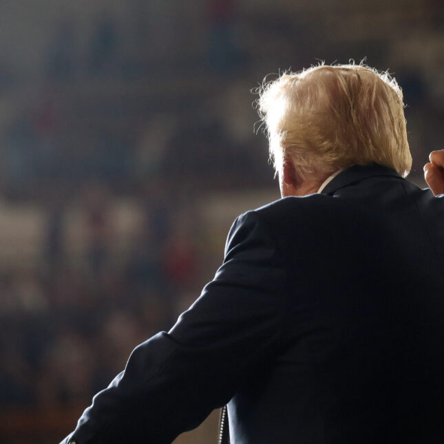 News photo of Donald Trump speaking to a crowd, photographed from the back